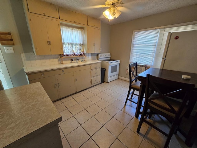 42 W 26th St, San Angelo, TX 76903 - kitchen featuring white appliances, healthy amount of natural light, light countertops, a sink, and a textured ceiling