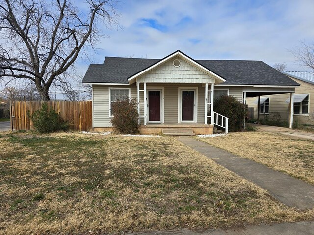 42 W 26th St, San Angelo, TX 76903 - ranch-style home featuring covered porch, a carport, and a shingled roof