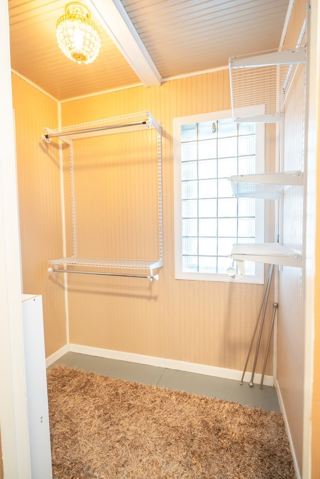 spacious closet featuring beamed ceiling and carpet flooring