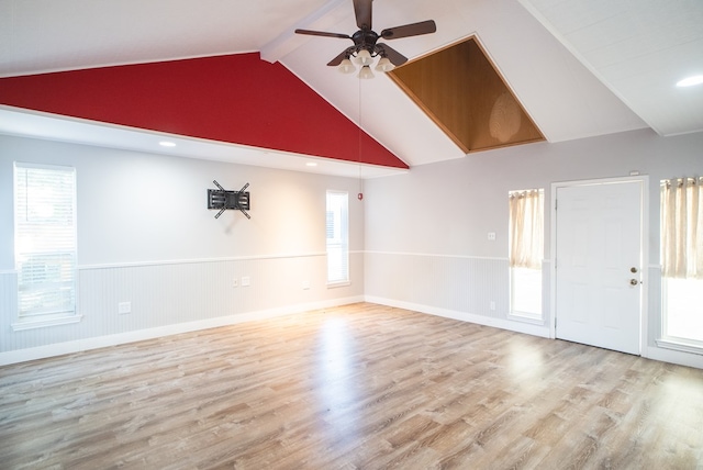 spare room with a wealth of natural light, light hardwood / wood-style floors, beamed ceiling, and ceiling fan