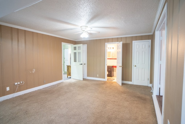 unfurnished bedroom featuring connected bathroom, crown molding, light carpet, a textured ceiling, and ceiling fan