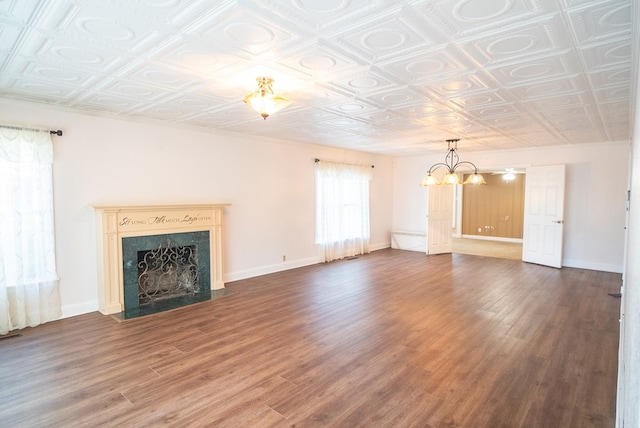 unfurnished living room featuring dark hardwood / wood-style floors, a chandelier, and a high end fireplace