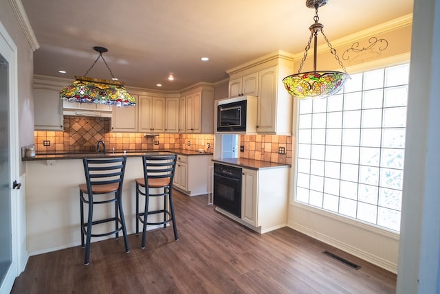 kitchen with built in microwave, dark hardwood / wood-style floors, black oven, and decorative light fixtures