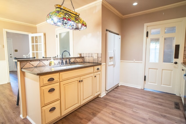 kitchen with crown molding, white refrigerator with ice dispenser, sink, and light hardwood / wood-style flooring