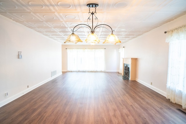 unfurnished living room featuring crown molding and dark hardwood / wood-style floors