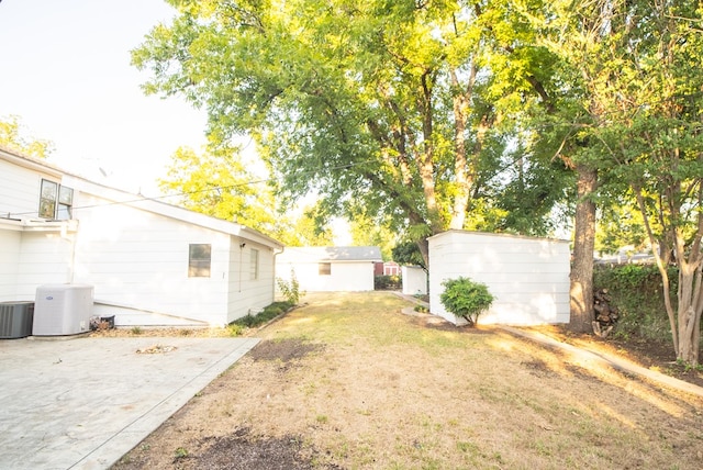 view of yard featuring a shed and central air condition unit