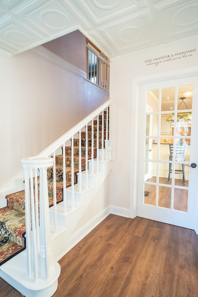 stairway with hardwood / wood-style flooring and french doors