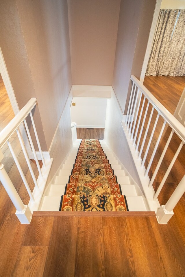 stairway with hardwood / wood-style floors