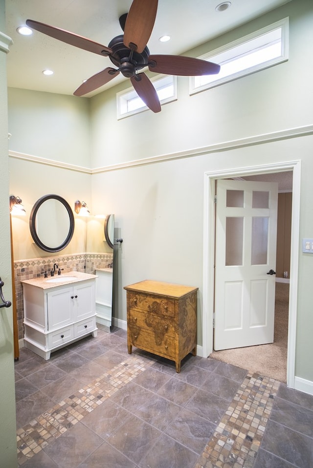 bathroom with vanity, a healthy amount of sunlight, and a high ceiling