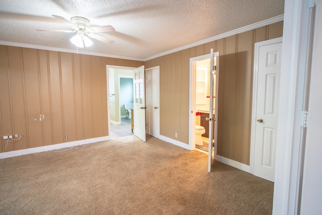 unfurnished bedroom featuring connected bathroom, crown molding, a textured ceiling, and carpet flooring