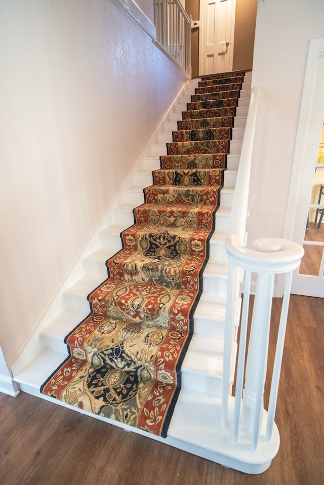 staircase with hardwood / wood-style flooring