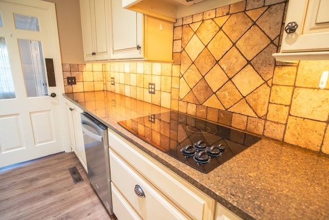 kitchen with tasteful backsplash, dishwasher, black electric cooktop, and light hardwood / wood-style flooring