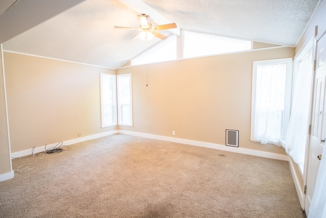 carpeted spare room featuring ceiling fan, a textured ceiling, and vaulted ceiling with beams