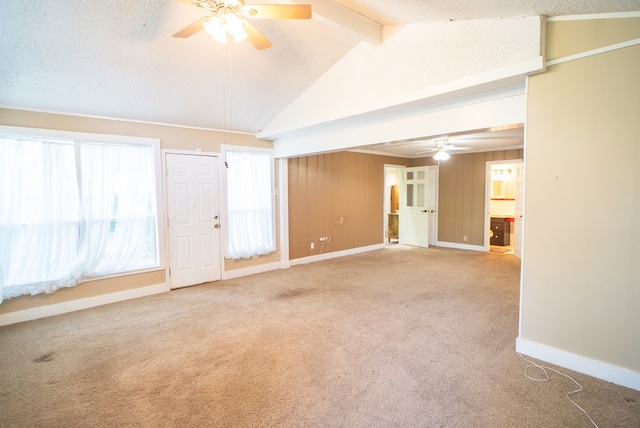 carpeted empty room with vaulted ceiling with beams, a textured ceiling, and ceiling fan