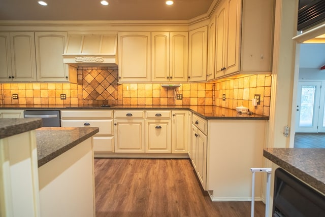 kitchen with custom exhaust hood, wood-type flooring, dark stone countertops, dishwasher, and black electric stovetop