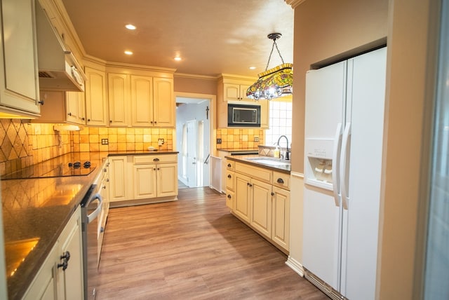 kitchen featuring light hardwood / wood-style floors, sink, hanging light fixtures, and black appliances