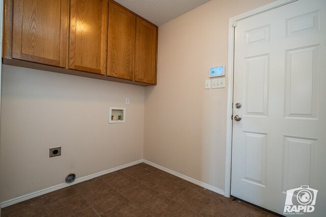 clothes washing area featuring cabinets, electric dryer hookup, washer hookup, and a textured ceiling