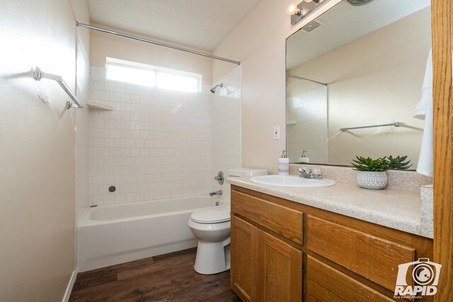 full bathroom featuring vanity, bathtub / shower combination, hardwood / wood-style floors, and toilet