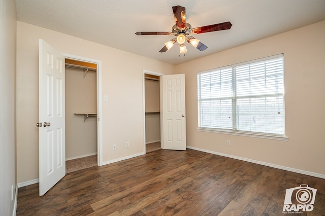 unfurnished bedroom with dark wood-type flooring and ceiling fan