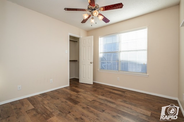 unfurnished bedroom with ceiling fan and dark hardwood / wood-style flooring