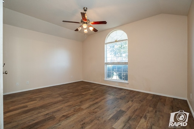 spare room with dark wood-type flooring, ceiling fan, vaulted ceiling, and a wealth of natural light