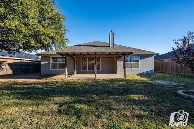 rear view of house featuring a yard and a patio area