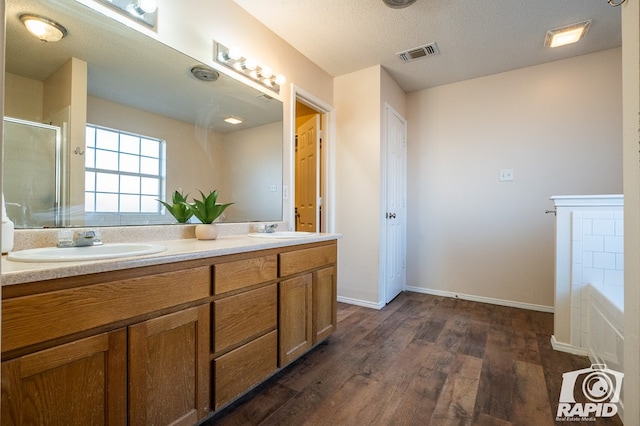 bathroom with vanity, wood-type flooring, independent shower and bath, and a textured ceiling