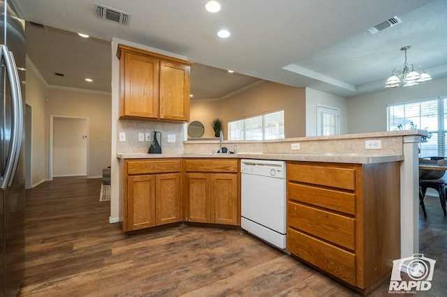 kitchen with stainless steel refrigerator, white dishwasher, kitchen peninsula, and backsplash