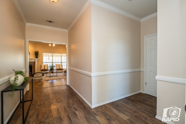 hall with crown molding, dark hardwood / wood-style floors, and a textured ceiling