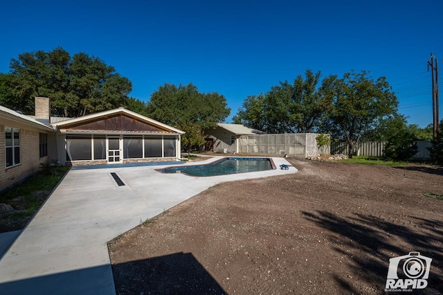 view of pool featuring a sunroom and a patio area