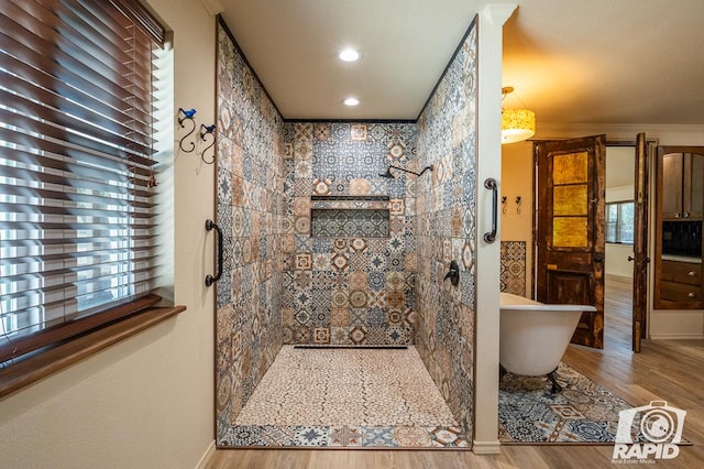 bathroom featuring hardwood / wood-style flooring, crown molding, and separate shower and tub