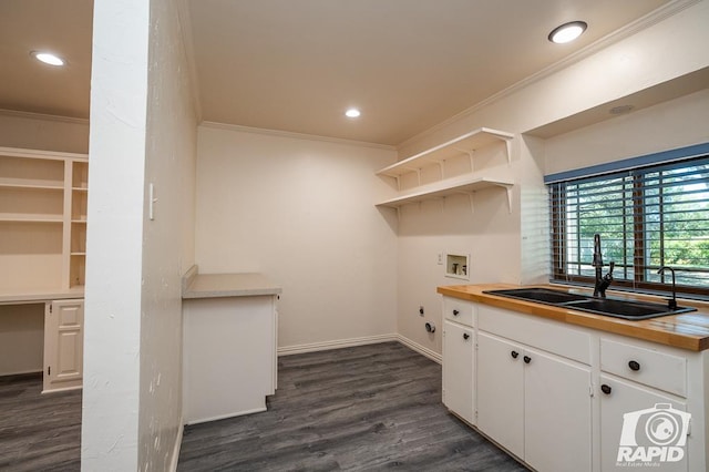 kitchen featuring white cabinetry, ornamental molding, sink, and dark hardwood / wood-style floors