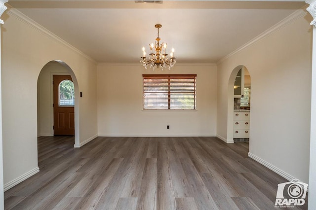 unfurnished dining area featuring hardwood / wood-style floors, ornamental molding, and a chandelier