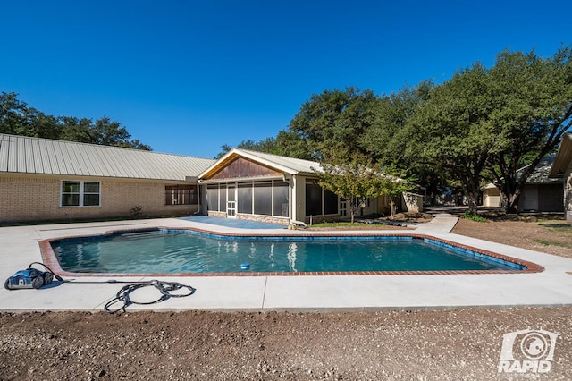 view of pool featuring a sunroom and a patio area