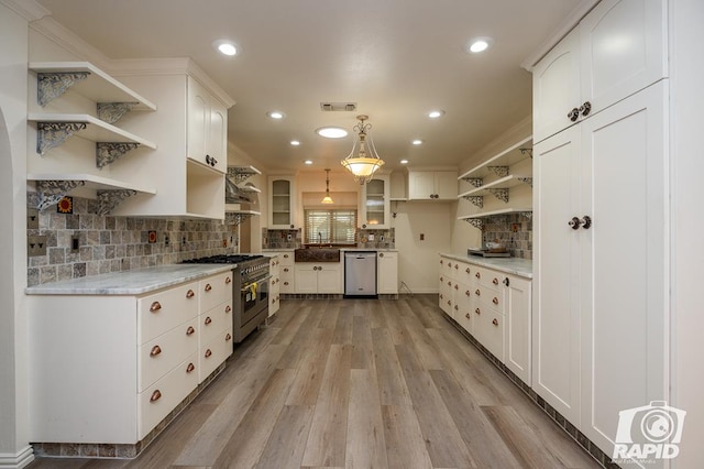 kitchen with pendant lighting, appliances with stainless steel finishes, light hardwood / wood-style flooring, and white cabinets