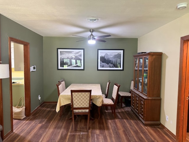 dining area featuring visible vents, a ceiling fan, dark wood finished floors, and baseboards