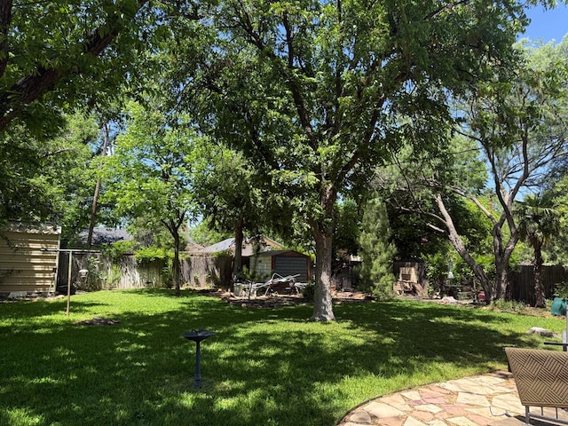 view of yard with an outdoor structure, a fenced backyard, and a storage shed
