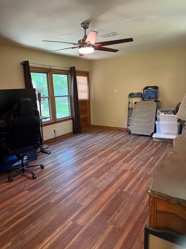 office space featuring visible vents, a ceiling fan, baseboards, and wood finished floors