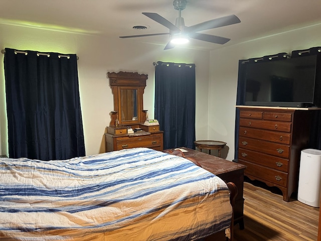bedroom featuring a ceiling fan, wood finished floors, and visible vents