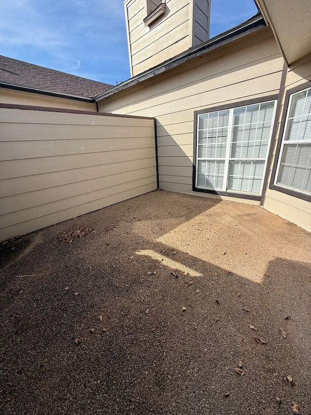 exterior space featuring a patio and roof with shingles