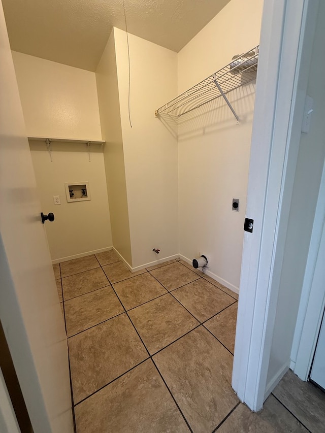 clothes washing area with baseboards, hookup for an electric dryer, laundry area, washer hookup, and tile patterned floors