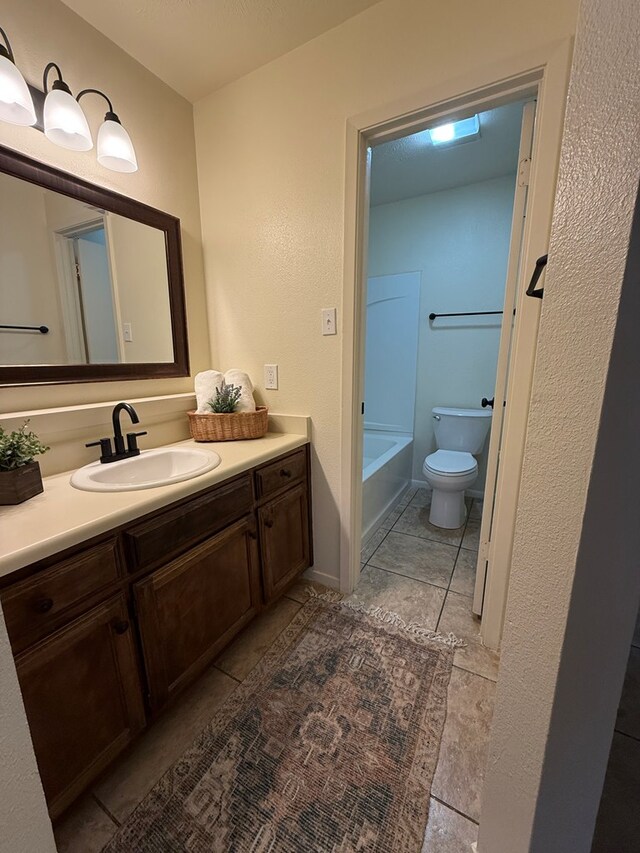 bathroom featuring a bathtub, toilet, and vanity