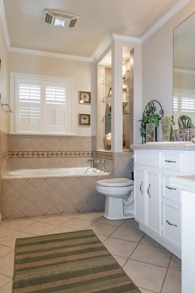 bathroom with tile patterned flooring, ornamental molding, toilet, vanity, and a relaxing tiled tub