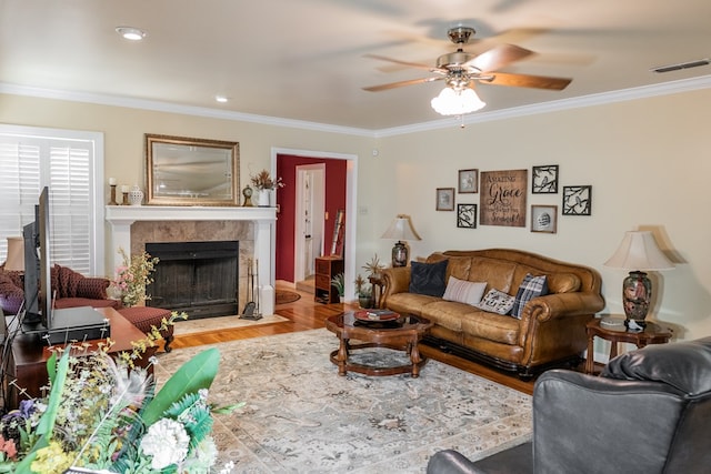 living room featuring a high end fireplace, crown molding, and hardwood / wood-style floors