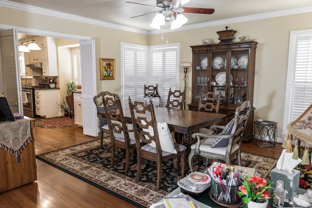 dining area featuring crown molding, wood-type flooring, and ceiling fan