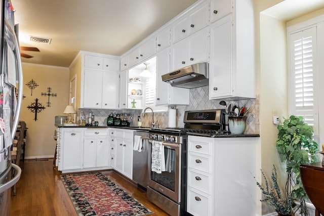 kitchen with dark hardwood / wood-style flooring, sink, a healthy amount of sunlight, appliances with stainless steel finishes, and white cabinets