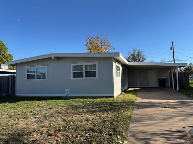 view of side of property featuring a carport and a yard