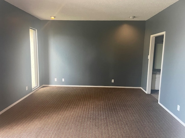 415 W Twohig Ave, San Angelo, TX 76903 - spare room featuring dark carpet, baseboards, and a smoke detector