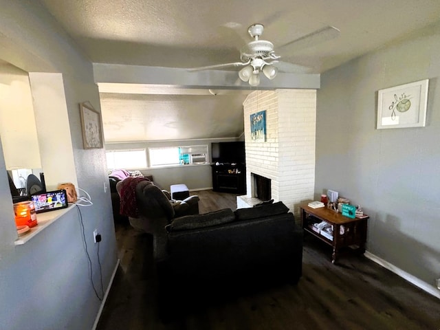 living room featuring wood-type flooring, a brick fireplace, a textured ceiling, and ceiling fan