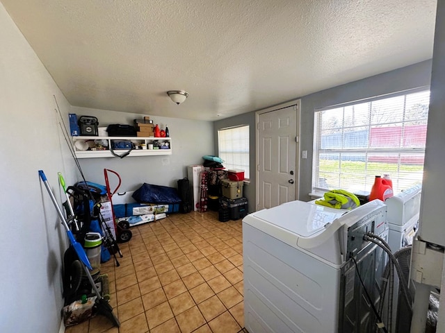 laundry room with washing machine and dryer, a healthy amount of sunlight, and a textured ceiling